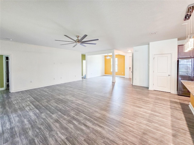 unfurnished living room featuring light hardwood / wood-style floors, a textured ceiling, and ceiling fan