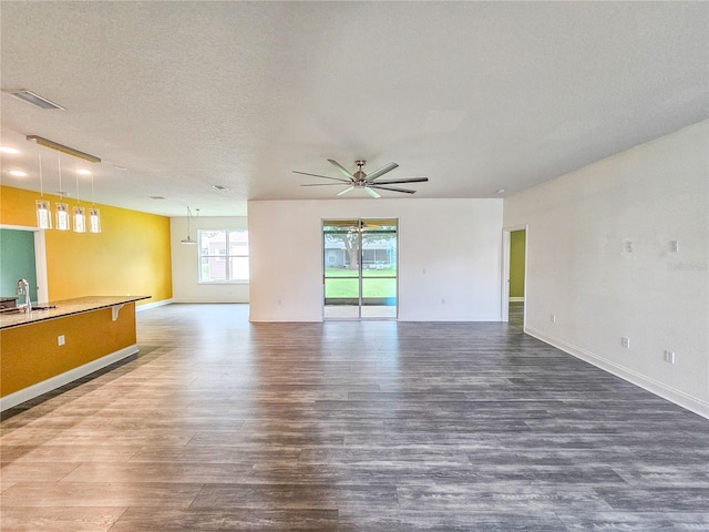 spare room with wood-type flooring, ceiling fan, sink, and a textured ceiling