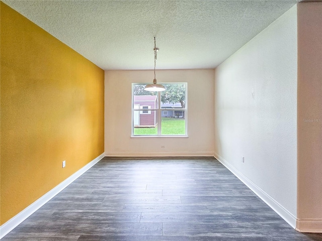 unfurnished dining area with dark wood-type flooring and a textured ceiling