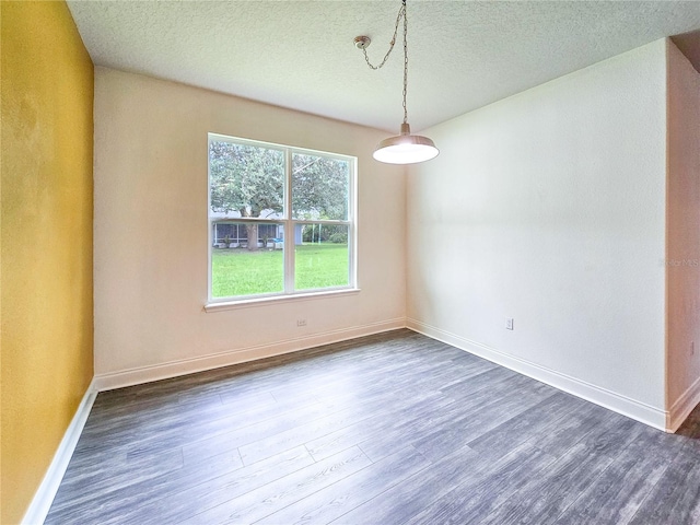 empty room featuring dark wood-type flooring and a textured ceiling