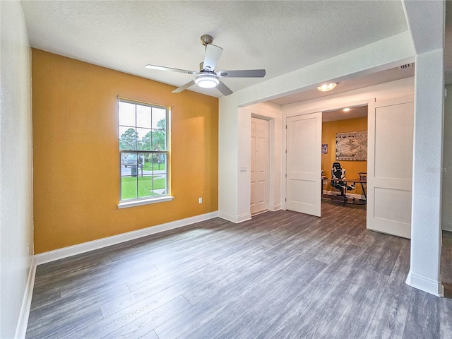 spare room with ceiling fan, dark hardwood / wood-style floors, and a textured ceiling