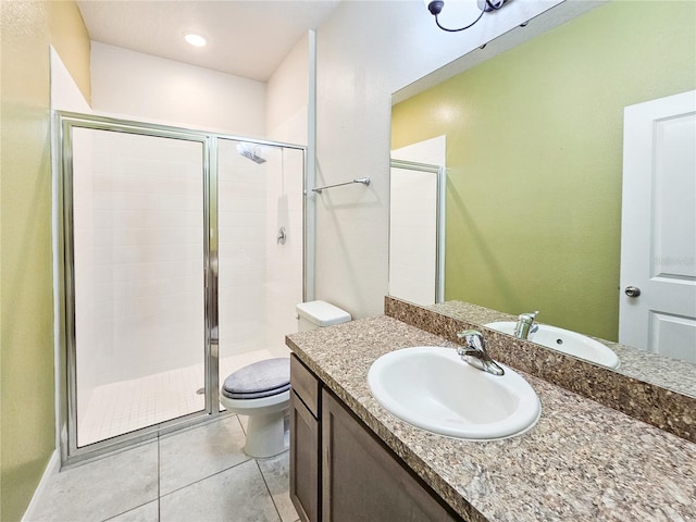 bathroom featuring tile patterned floors, vanity, toilet, and a shower with shower door