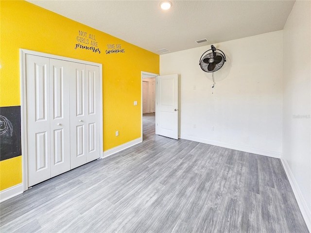 unfurnished bedroom with a closet and light hardwood / wood-style floors