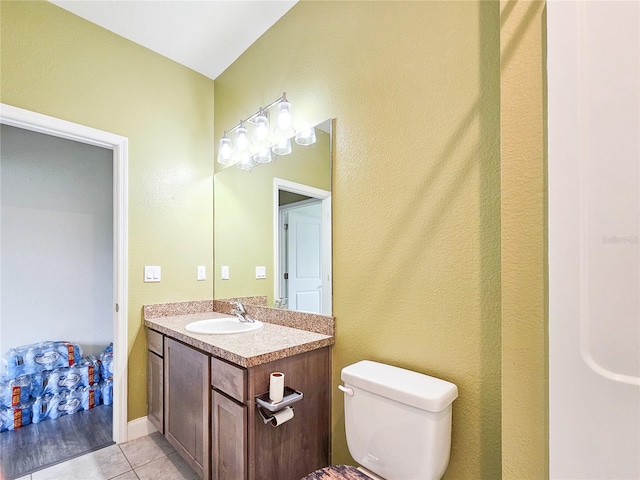 bathroom with vanity, tile patterned flooring, and toilet