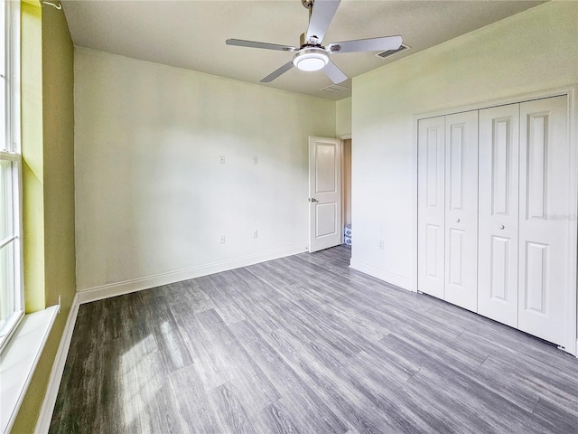 unfurnished bedroom featuring ceiling fan, light hardwood / wood-style flooring, and a closet