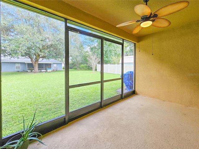 unfurnished sunroom with ceiling fan