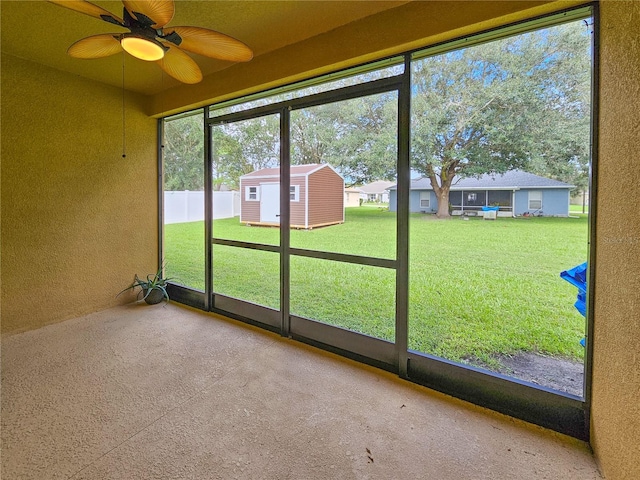 unfurnished sunroom with ceiling fan