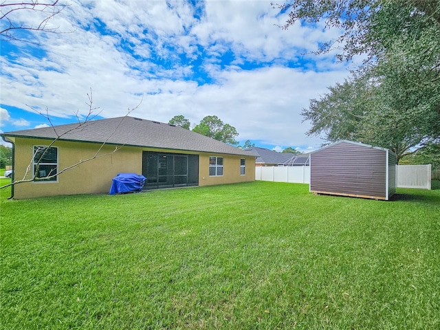 rear view of house featuring a yard and a storage shed