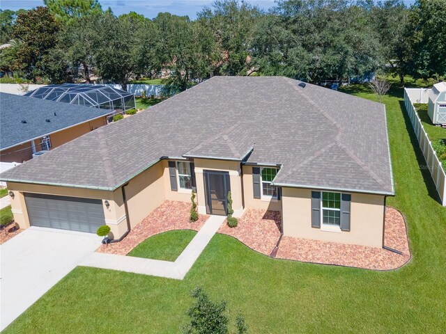 single story home featuring a garage, a front lawn, and glass enclosure