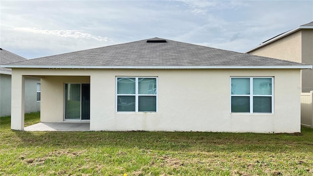 back of property featuring a lawn