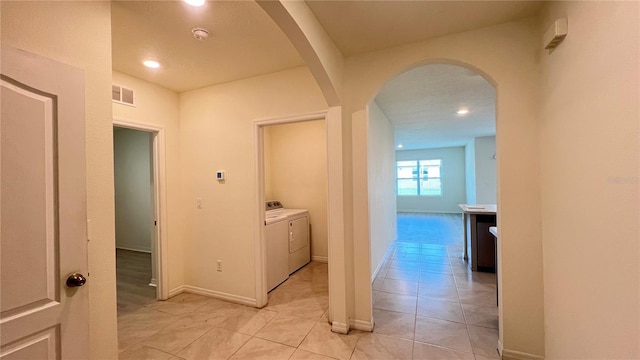 corridor with light tile patterned flooring and washing machine and clothes dryer