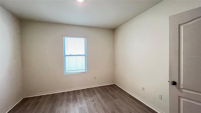 spare room with dark wood-type flooring