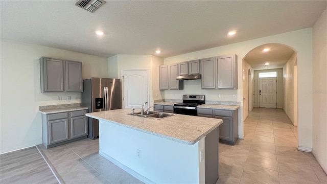 kitchen with gray cabinets, a kitchen island with sink, stainless steel appliances, and sink