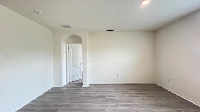 unfurnished room featuring a textured ceiling and hardwood / wood-style floors