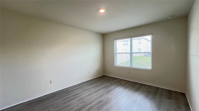 spare room with dark hardwood / wood-style flooring