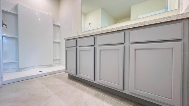 bathroom featuring walk in shower, vanity, and tile patterned flooring