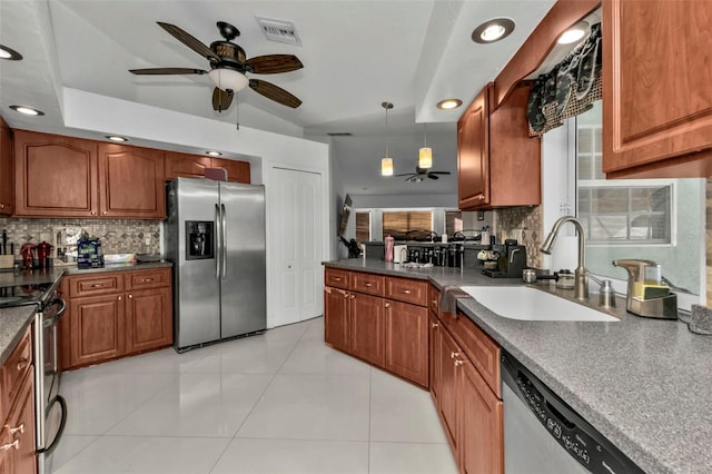 kitchen featuring hanging light fixtures, sink, light tile patterned floors, appliances with stainless steel finishes, and tasteful backsplash