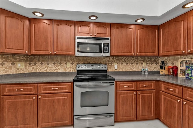 kitchen with decorative backsplash, light tile patterned floors, and appliances with stainless steel finishes