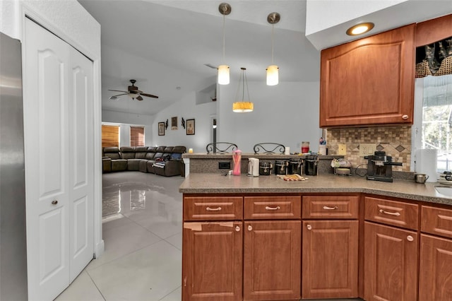 kitchen with backsplash, ceiling fan, pendant lighting, light tile patterned floors, and lofted ceiling