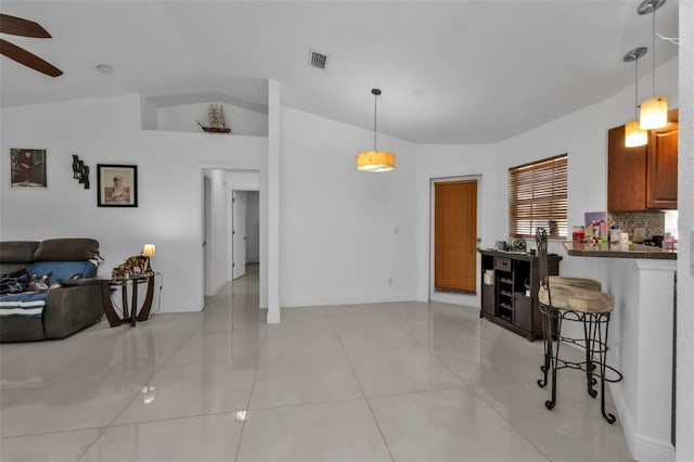 kitchen with decorative backsplash, a breakfast bar, light tile patterned floors, and hanging light fixtures