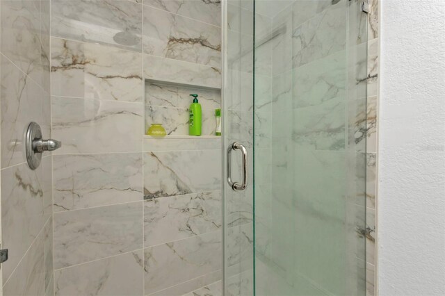 bathroom with a shower with door