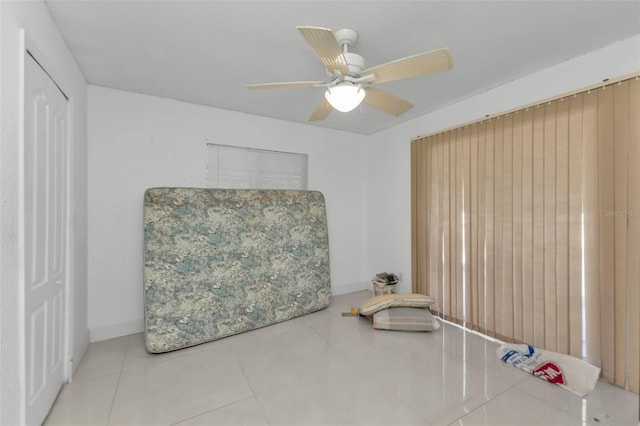 living area featuring tile patterned floors and ceiling fan