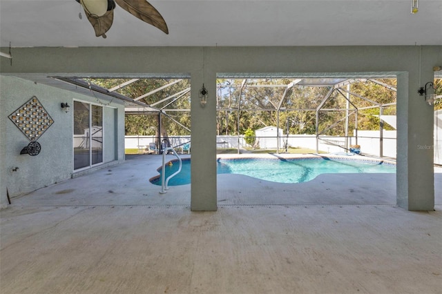 view of pool with glass enclosure and a patio