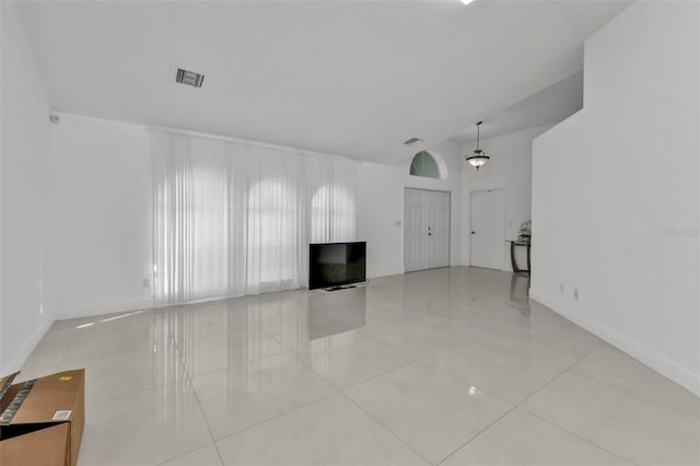 unfurnished living room featuring light tile patterned flooring and lofted ceiling