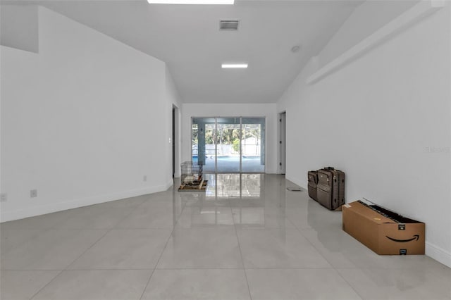 empty room with light tile patterned flooring and lofted ceiling