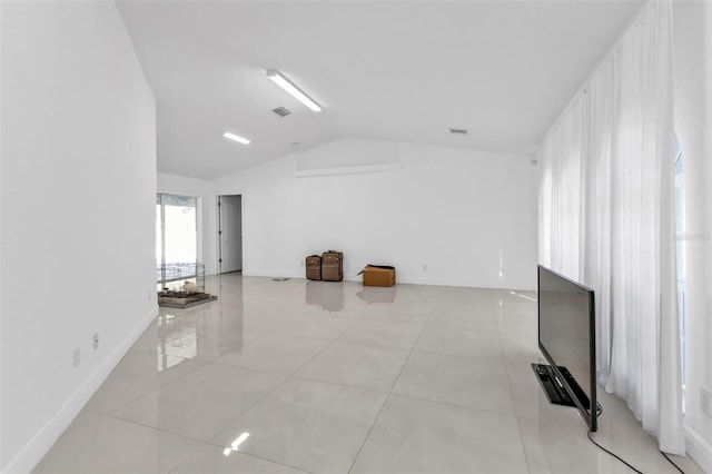 unfurnished living room with light tile patterned flooring and vaulted ceiling