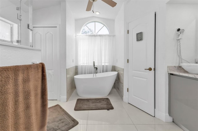 bathroom with vanity, ceiling fan, tile patterned flooring, lofted ceiling, and a tub