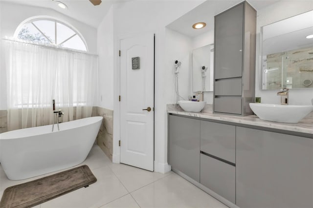 bathroom with tile patterned floors, vanity, independent shower and bath, and lofted ceiling