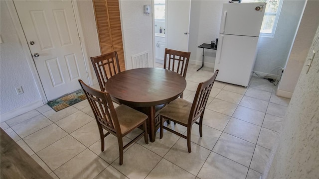 dining space featuring light tile patterned flooring