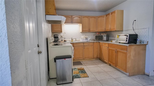 kitchen with light tile patterned flooring, extractor fan, tasteful backsplash, light brown cabinetry, and range