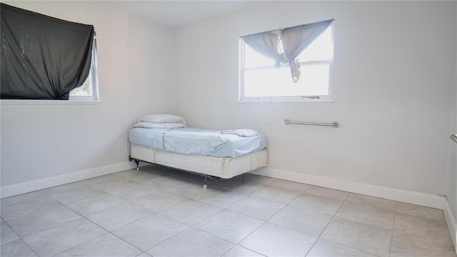 unfurnished bedroom featuring light tile patterned floors and multiple windows