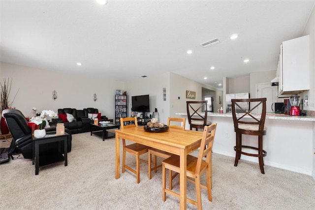 dining room with light colored carpet