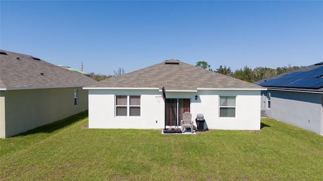 rear view of property featuring a lawn