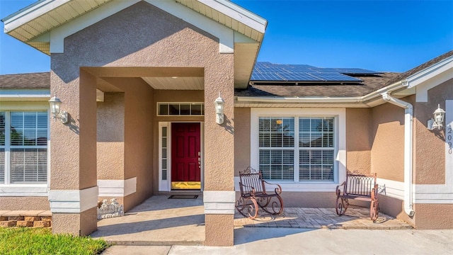 entrance to property with solar panels and a patio