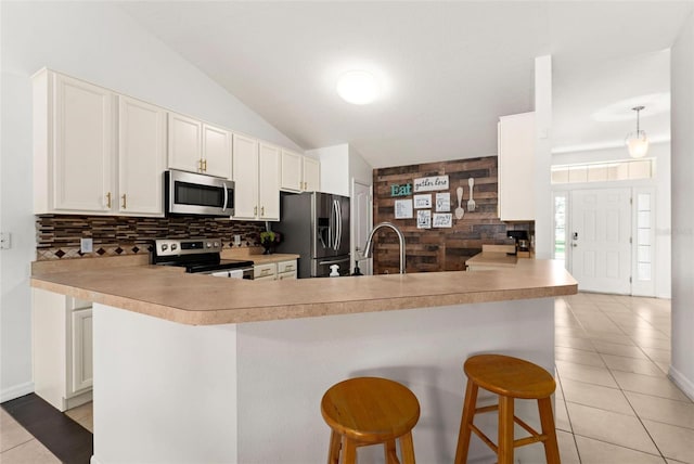 kitchen with kitchen peninsula, sink, stainless steel appliances, and a breakfast bar