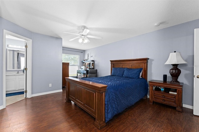 bedroom with ceiling fan, dark wood-type flooring, sink, ensuite bathroom, and a textured ceiling