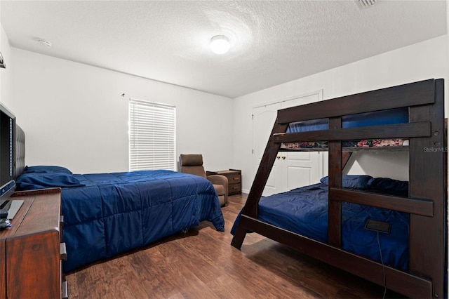 bedroom featuring dark hardwood / wood-style floors and a textured ceiling