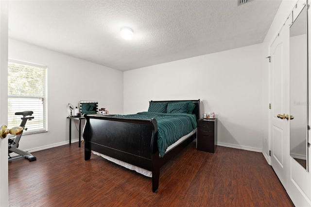 bedroom featuring dark wood-type flooring and a textured ceiling