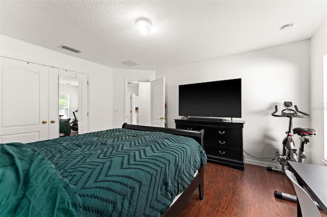 bedroom featuring a textured ceiling, a closet, and dark wood-type flooring