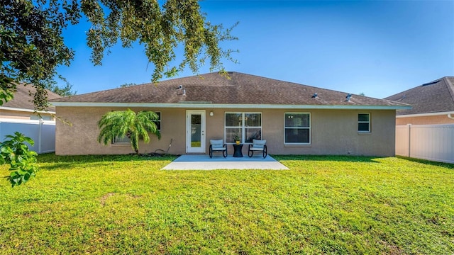 back of house with a yard and a patio