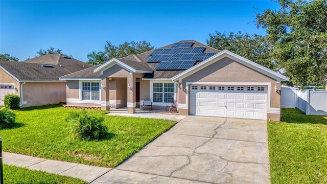 view of front facade featuring a garage, a front lawn, and solar panels