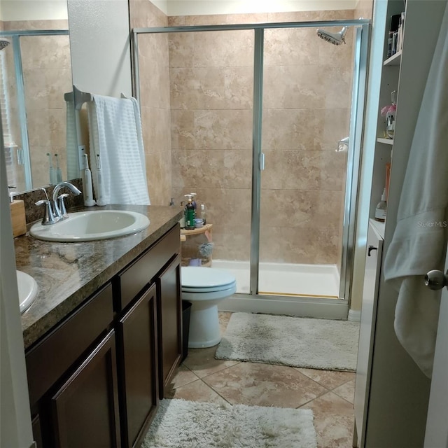 bathroom with vanity, toilet, tile patterned floors, and a shower with door