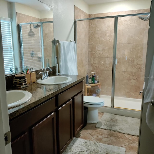 bathroom with vanity, toilet, tile patterned floors, and a shower with door