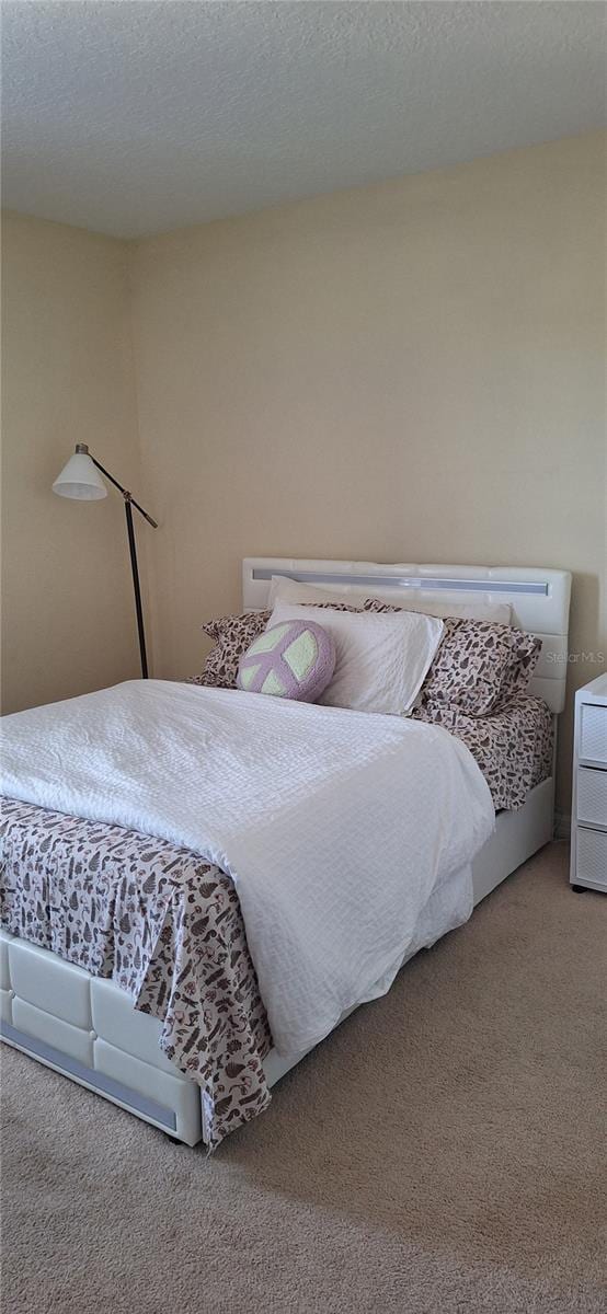 bedroom with a textured ceiling and carpet floors