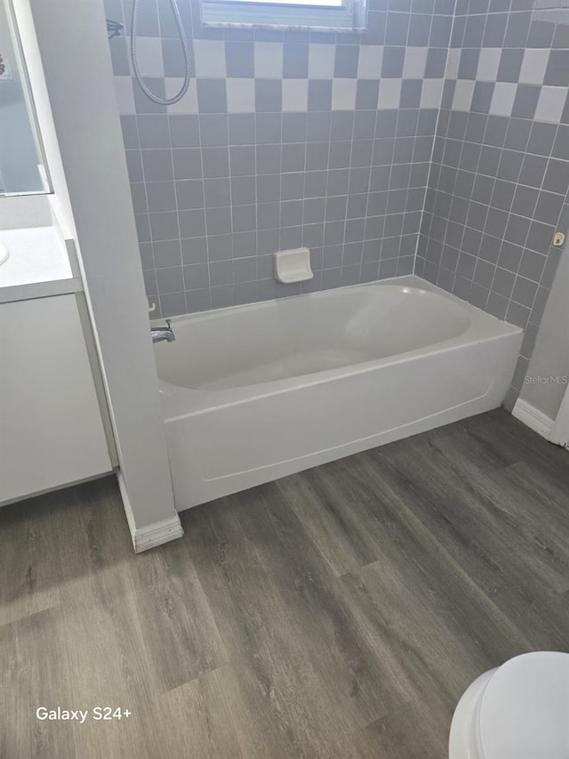 full bathroom featuring vanity, hardwood / wood-style flooring, toilet, and tiled shower / bath