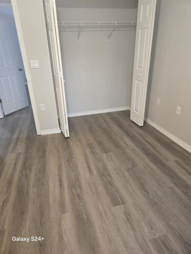 unfurnished bedroom featuring dark wood-type flooring and a closet